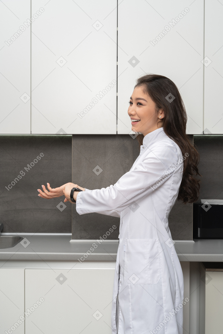 Vista lateral de uma mulher rindo em jaleco branco
