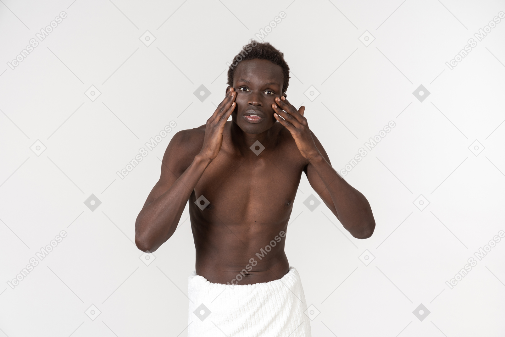 一个年轻的黑人男子在他的腰部做着白色浴巾做他的早晨例行公事
