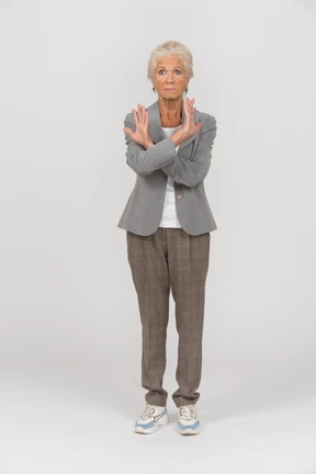 Front view of an old lady in suit showing stop sign