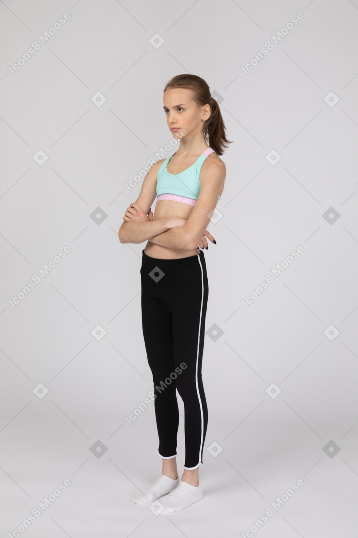 Upset teen girl standing with her arms crossed