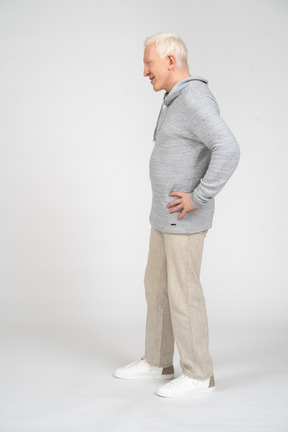 Side view of man standing with his hands on his hips