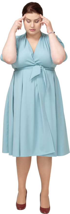 頭に触れる青いドレスの女性の正面図