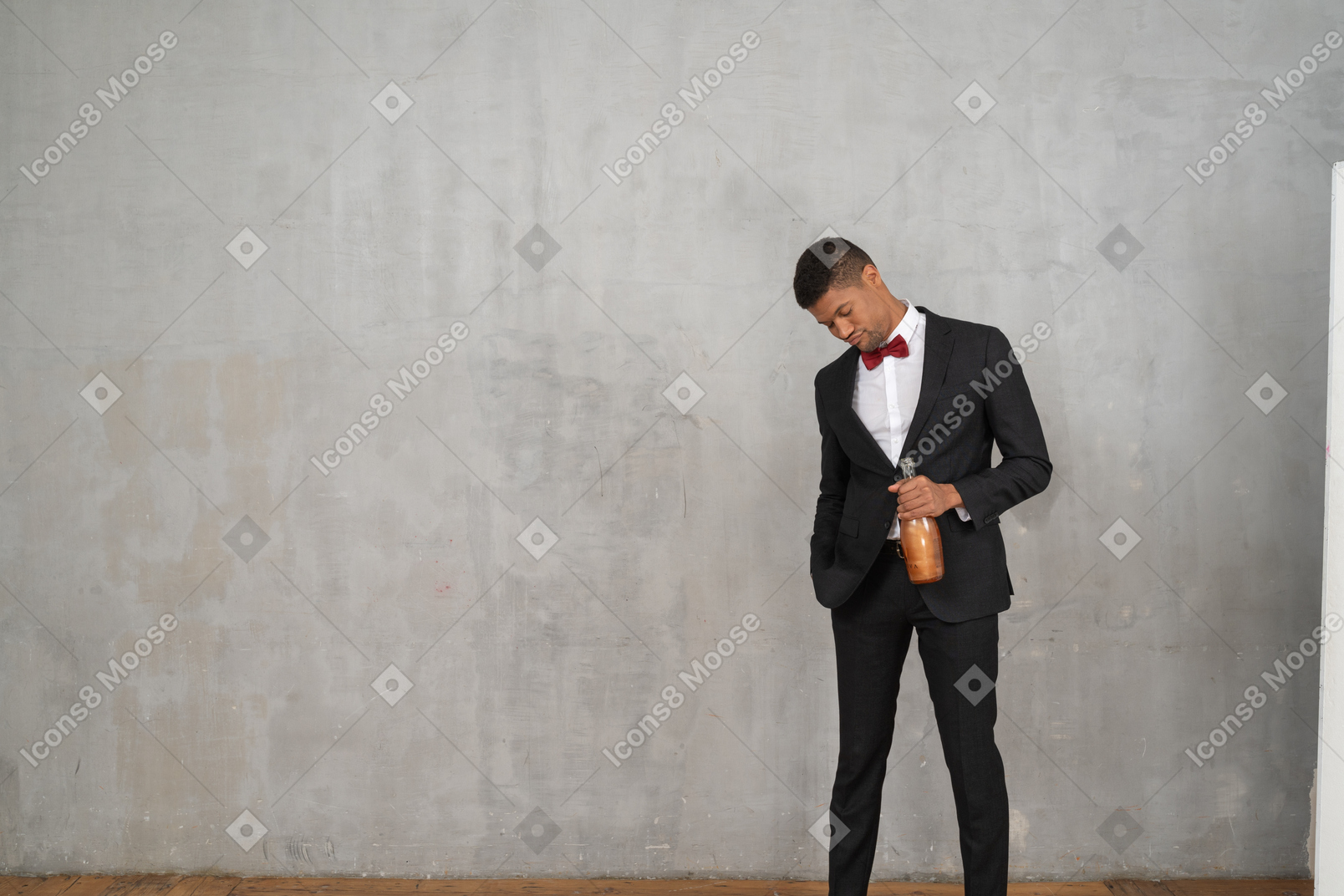 Tipsy man holding a champagne bottle and looking down