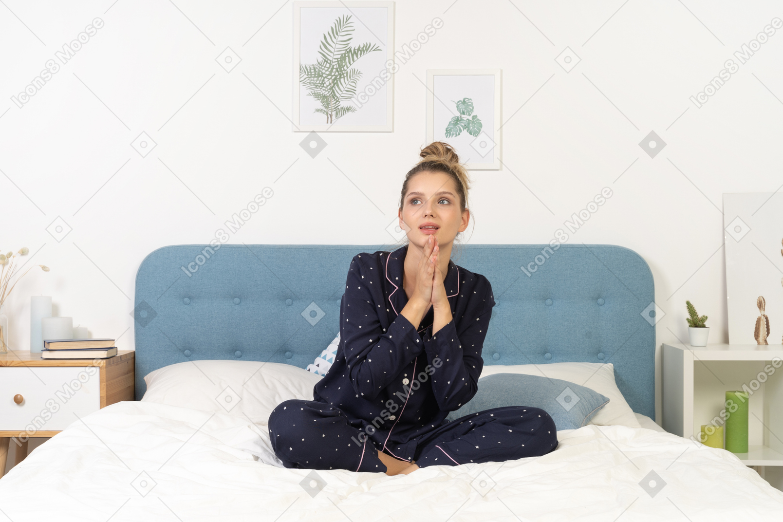 一个穿着睡衣的年轻女子躺在床上，手牵着手的前视图