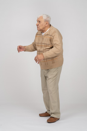 Side view of an old man in casual clothes staring at something