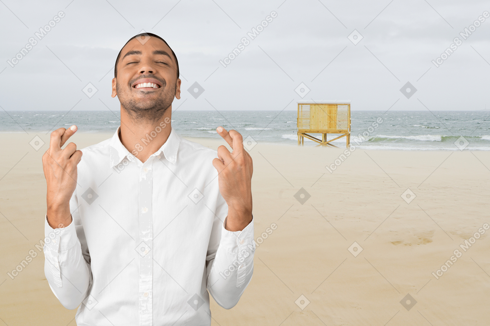 A man standing on a beach with his fingers crossed