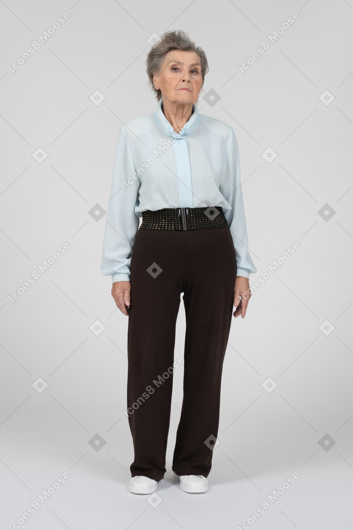 Old woman standing still and looking at camera