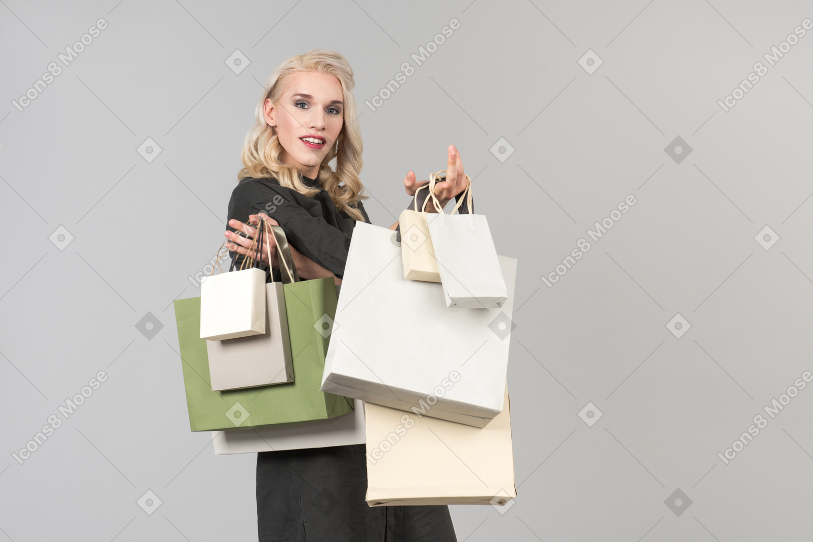 Una joven rubia hermosa con un vestido negro con un montón de bolsas de compras en ambas manos