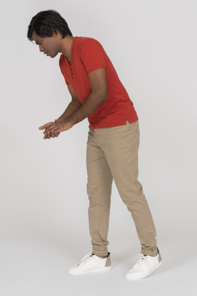 Young man with folded hands bending down