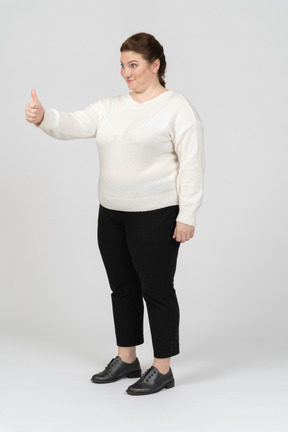 Plump woman in casual clothes showing thumb up