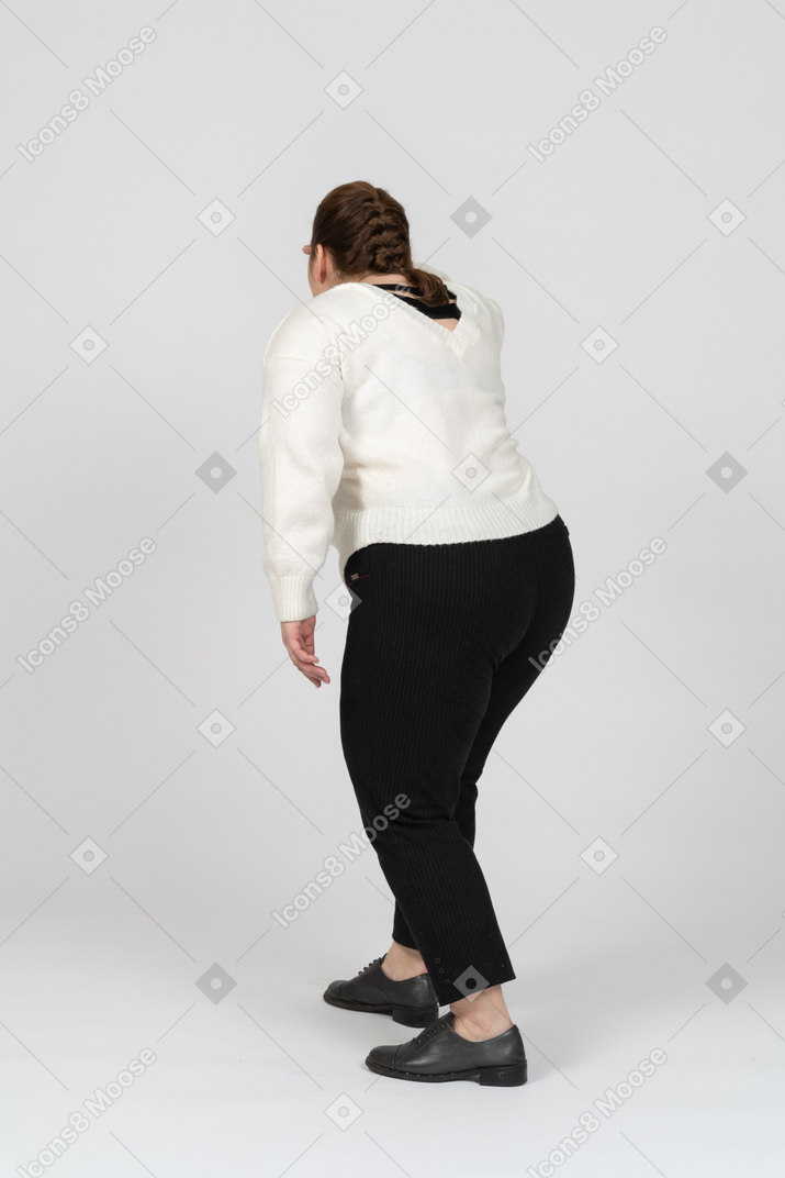 Rear view of plump woman in casual clothes looking for someone