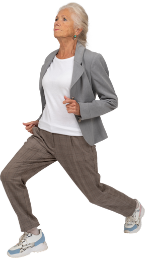 Side view of an old lady in suit doing front lunges