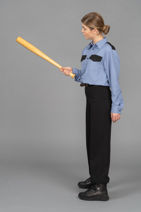 Female security guard pointing with a baseball bat
