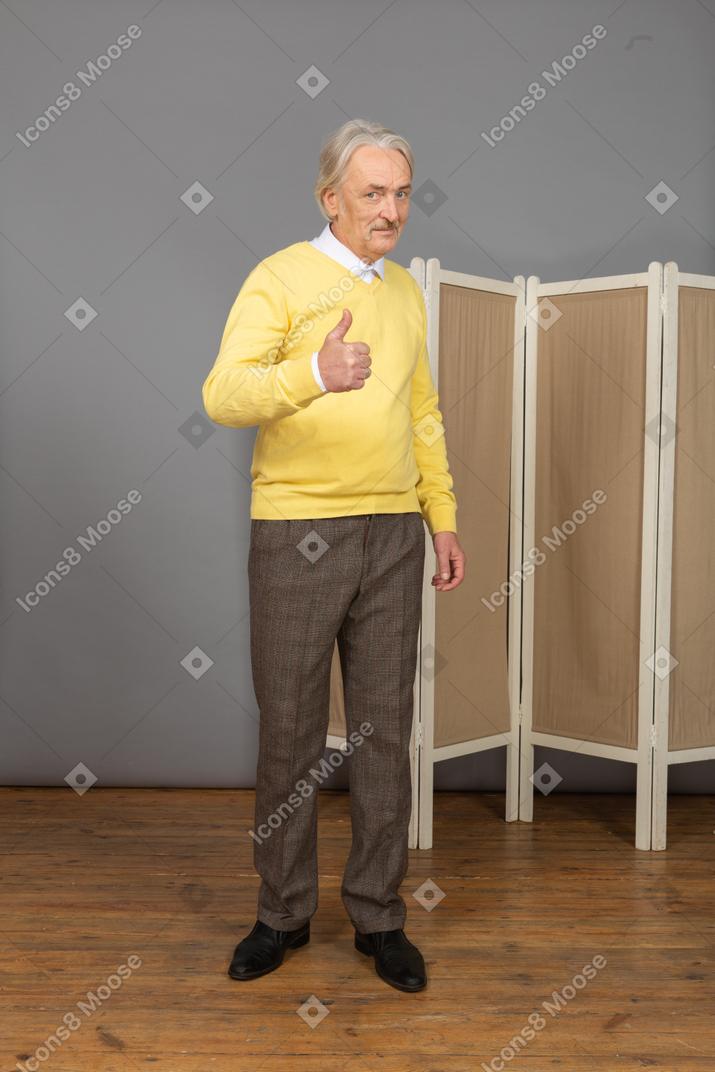 Vista frontal de un anciano mostrando el pulgar hacia arriba