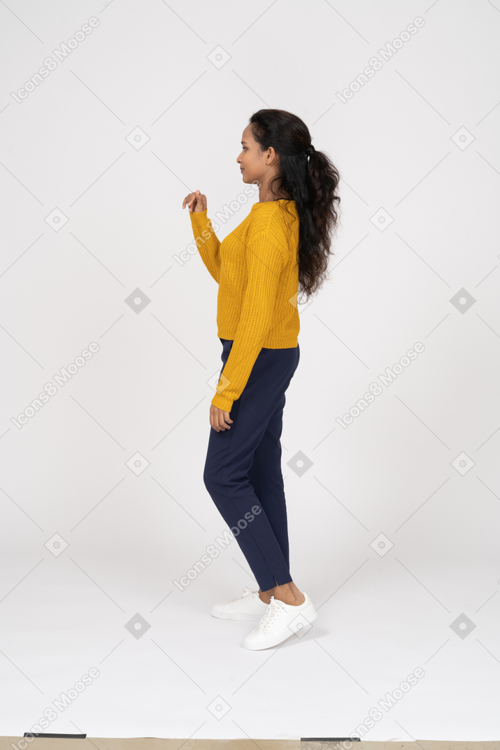 Side view of a girl in casual clothes waving