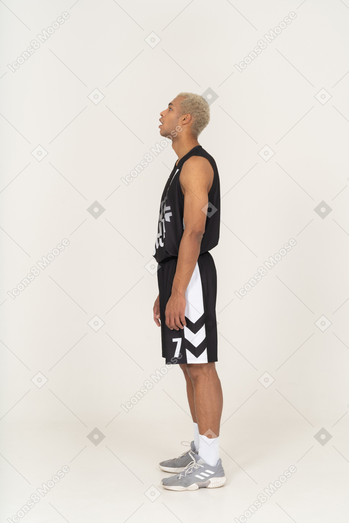 一个喘着粗气的年轻男篮球运动员的侧视图