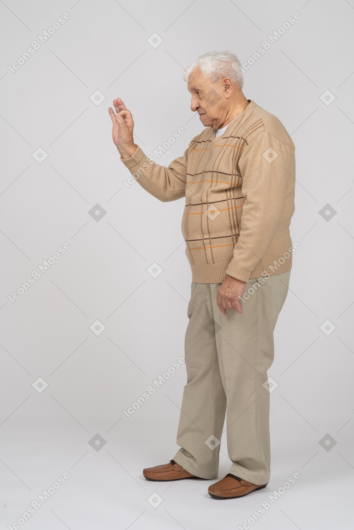 Vista lateral de un anciano con ropa informal que muestra un gesto correcto