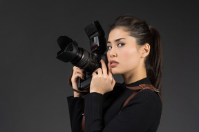 Jovem mulher segurando a câmera e posando para uma foto