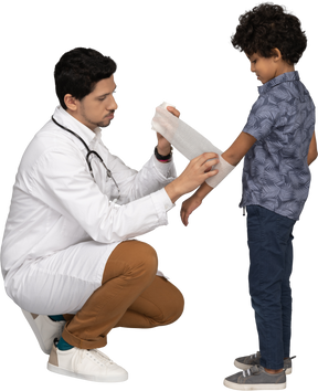 Médico enfaixando a mão de uma criança