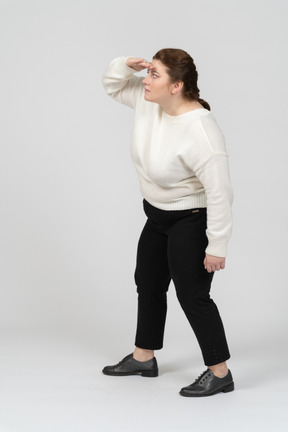 Vista lateral de uma mulher plus size com roupas casuais procurando por alguém