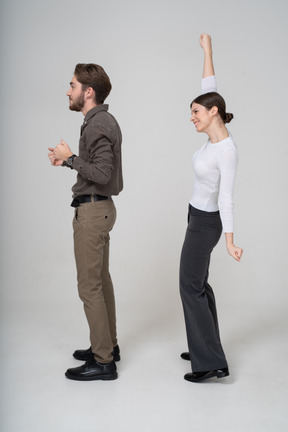 Side view of a delighted young couple in office clothing
