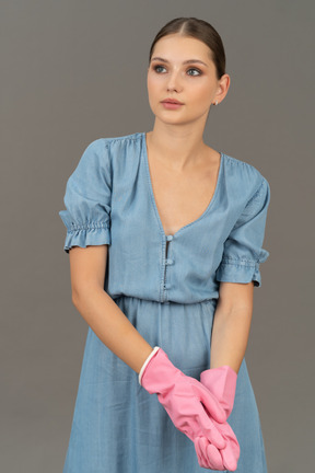 Young woman holding her own hand while wearing pink gloves