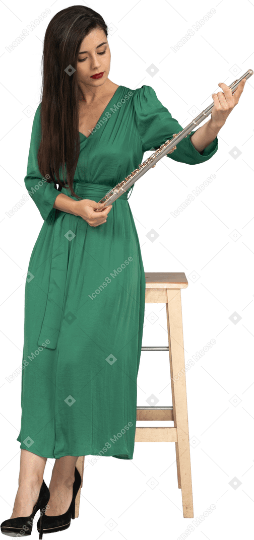 一位年轻的女士，穿着绿色的衣服，坐在椅子上，拿着单簧管的前视图