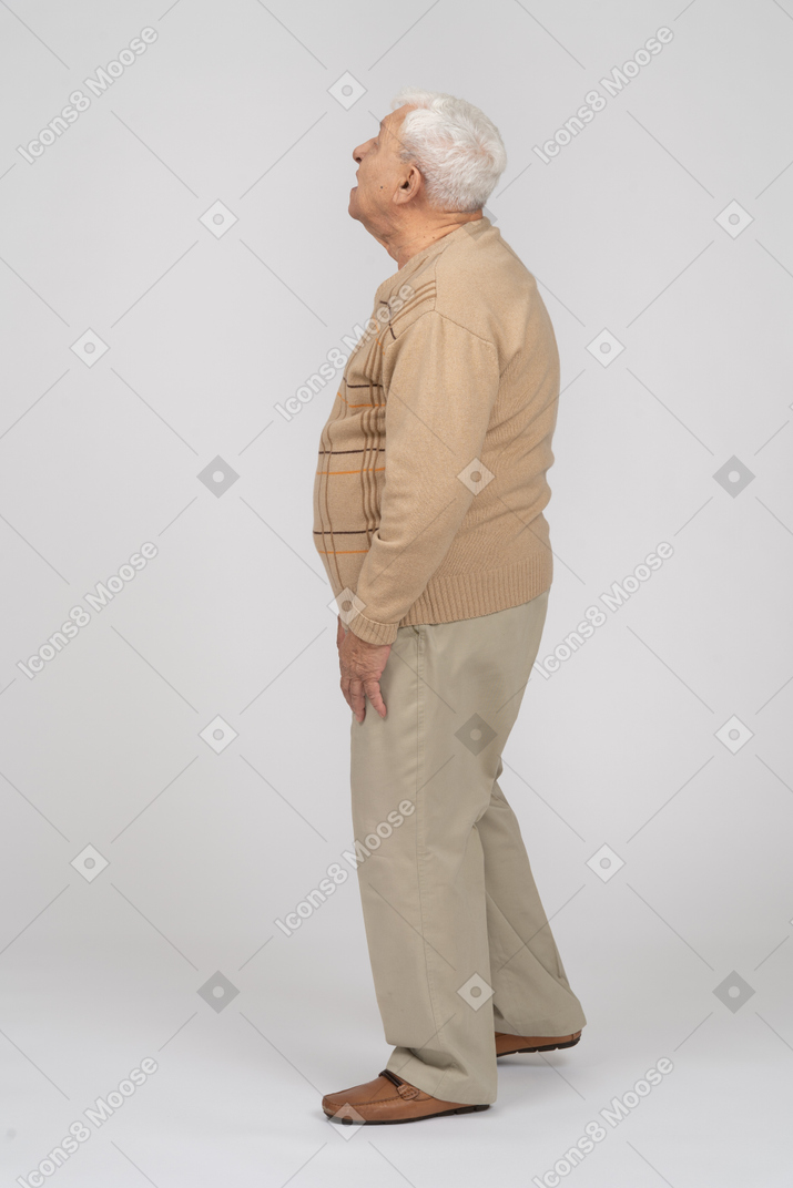 一位穿着休闲服的老人抬头仰望的侧视图