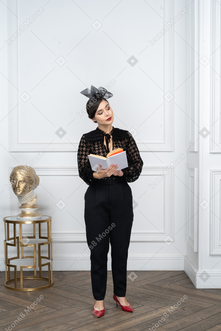 Jeune femme avec un livre dans les mains regardant de côté