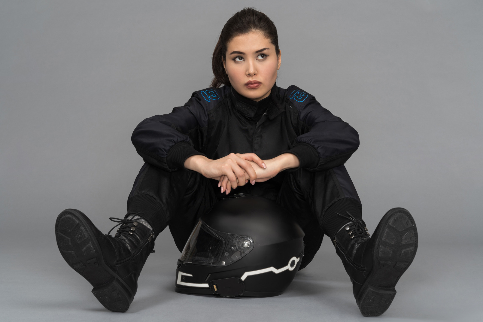 A self-confident young woman sitting with a helmet between her legs