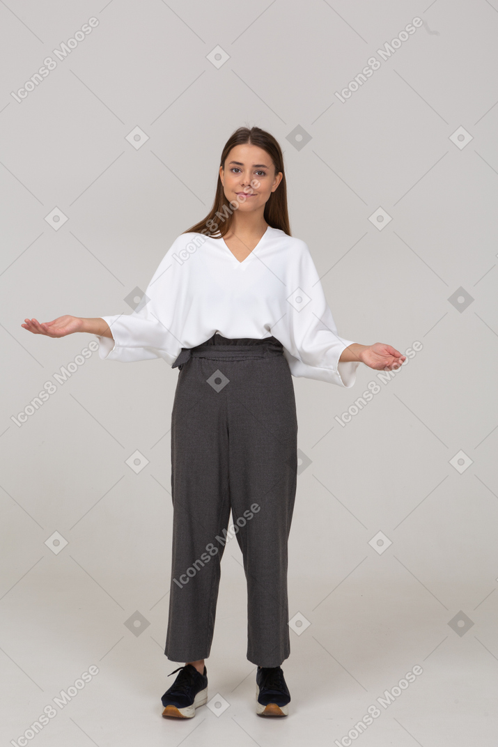 Vue de face d'une jeune femme en vêtements de bureau écartant les mains