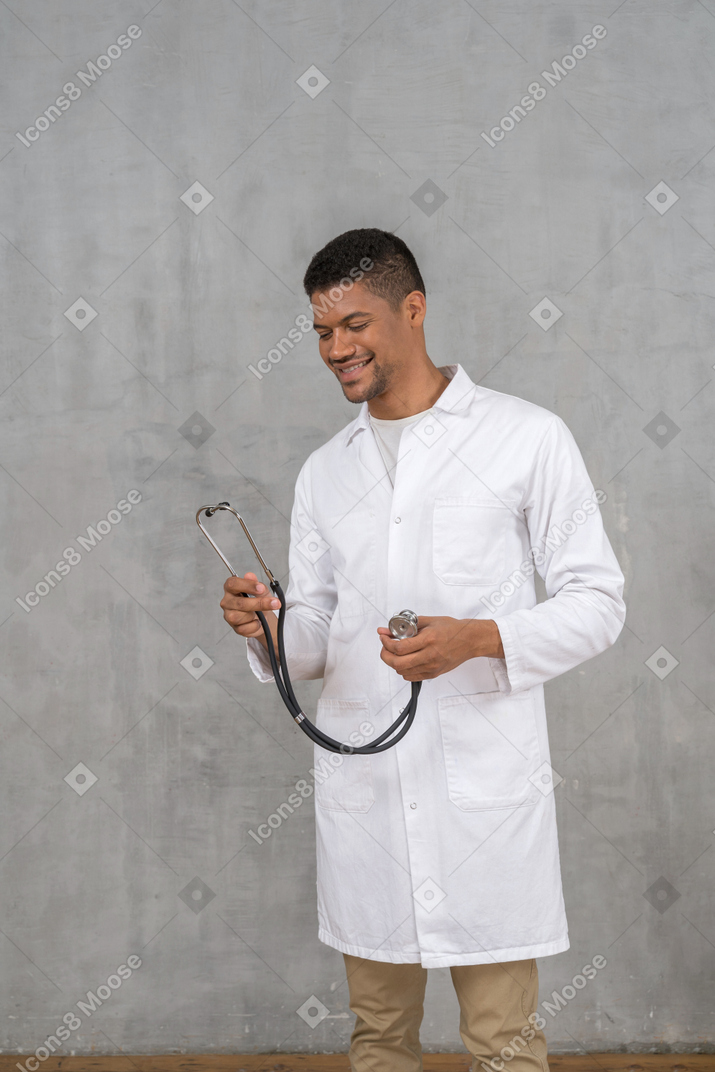 Médico masculino sorridente segurando um estetoscópio