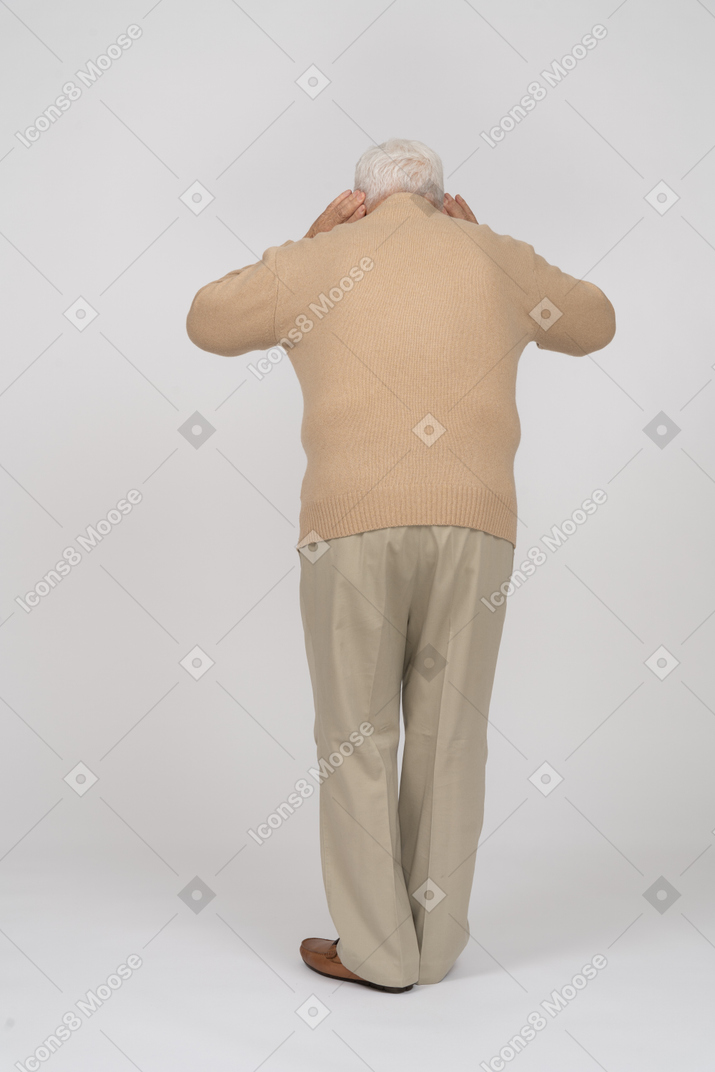 Rear view of an old man in casual clothes listening attentively