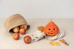 Apples in basket, pumpkin, orange slices and cinnamon sticks