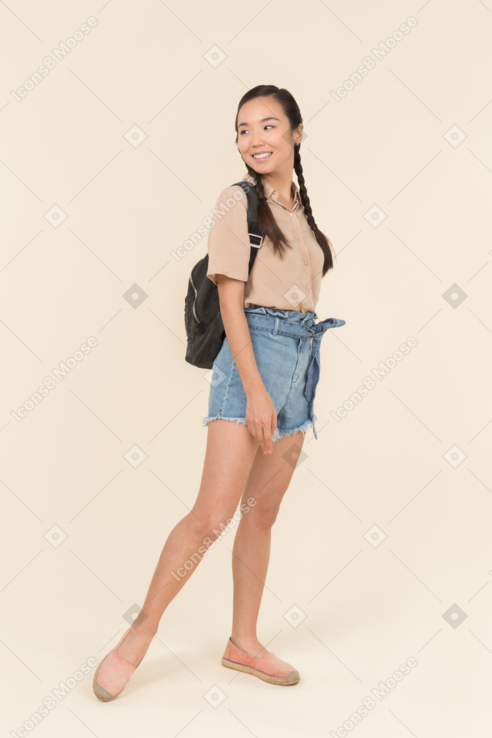 Jeune femme joyeuse dans des vêtements décontractés regardant loin