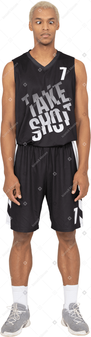 Vue de face d'un jeune joueur de basket-ball masculin qui louche