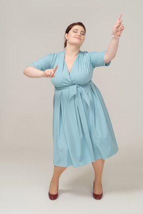 Вид спереди танцующей женщины в синем платье
