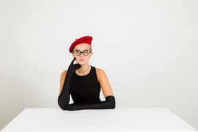 Mujer joven elegante en boina roja y gafas