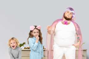 A dressed-up man, a girl with cat ears and a laughing boy