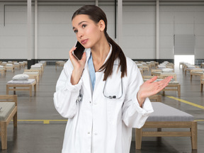 A woman in a lab coat talking on a cell phone