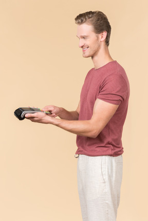 Young guy using a payment terminal