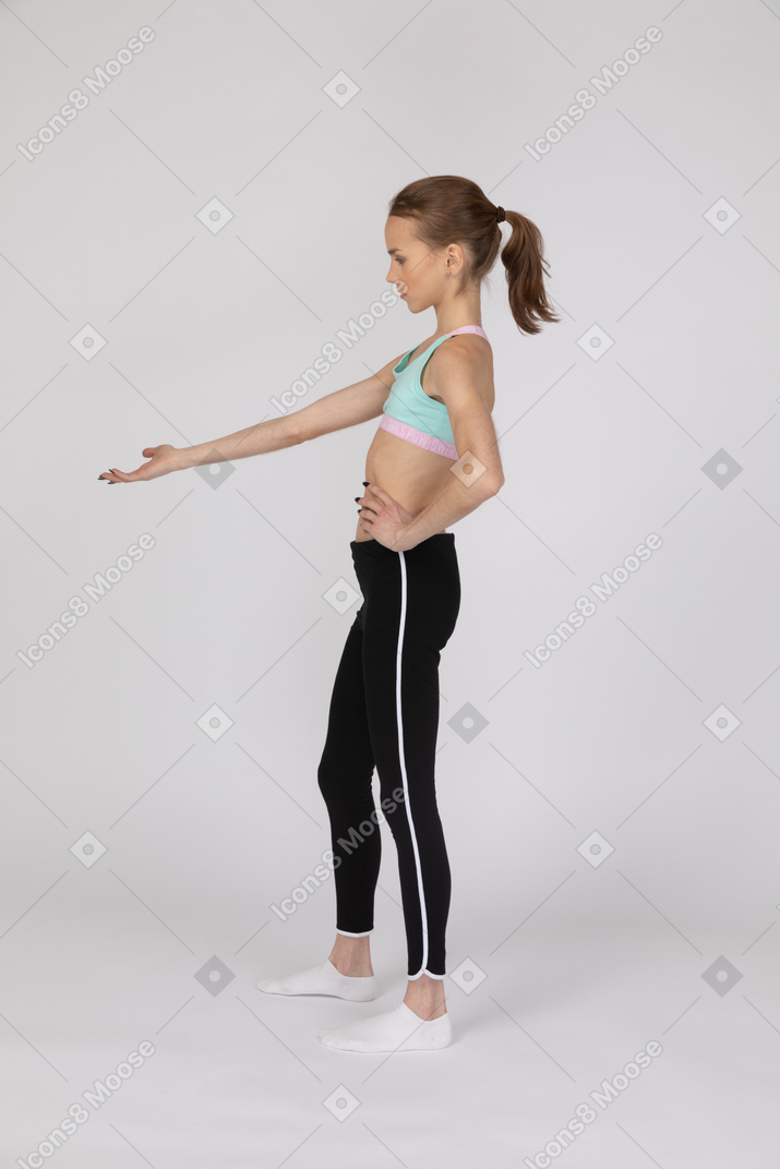 一个穿着运动服的少女用手朝下的侧视图