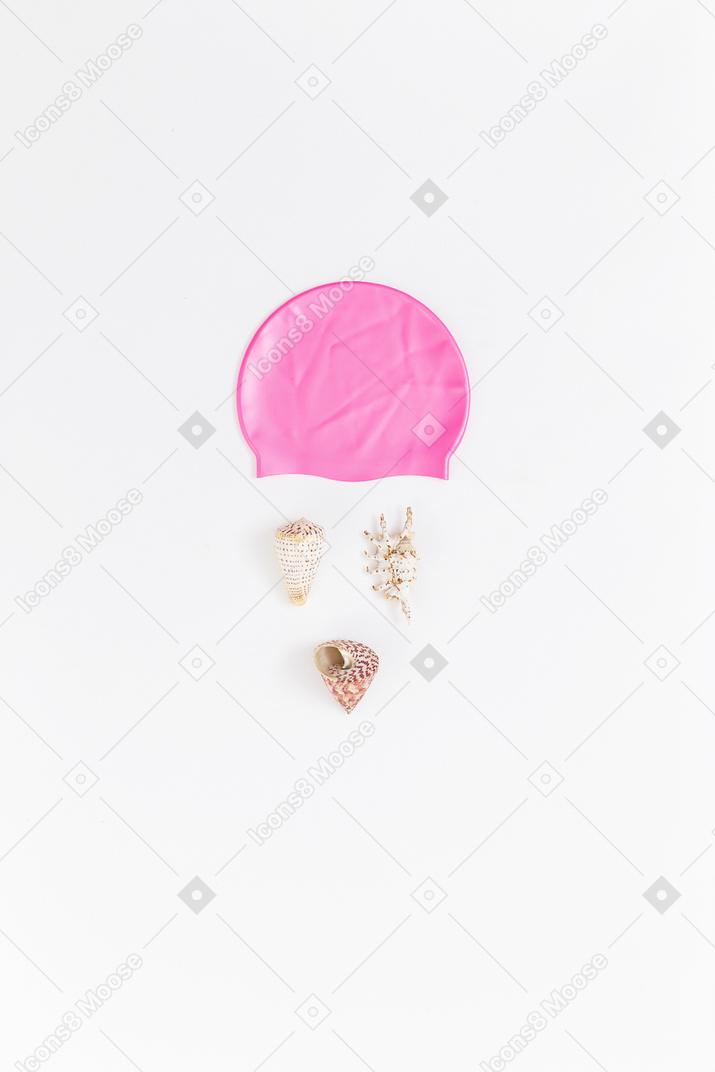 Imitação de rosto feita de conchas e touca rosa