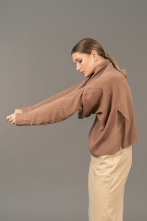 Jeune femme enlevant ses vêtements de ses bras