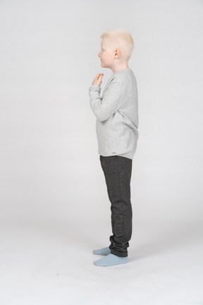 Side view of a little boy with raised arms