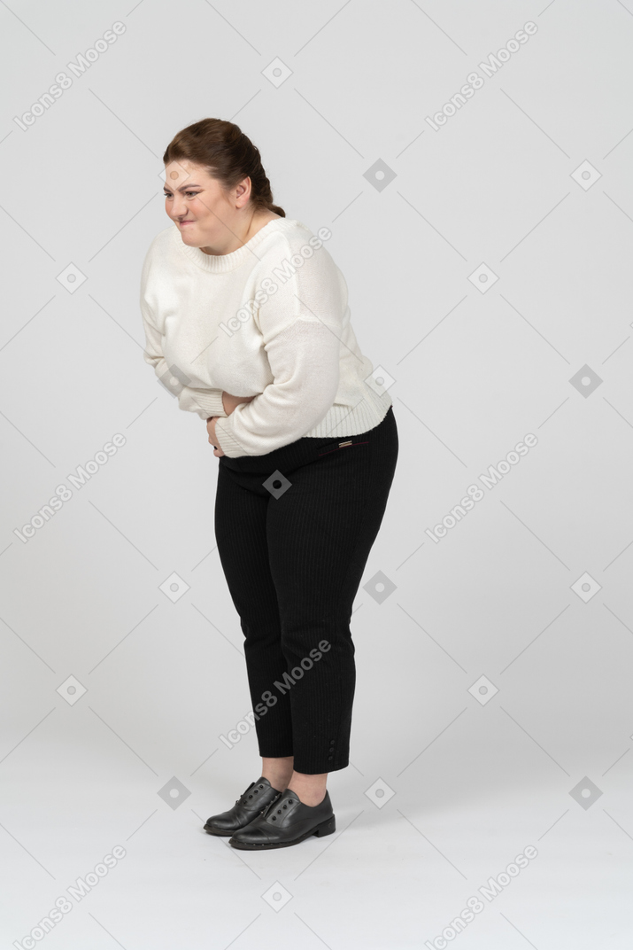 Plump woman in casual clothes suffering from stomach ache