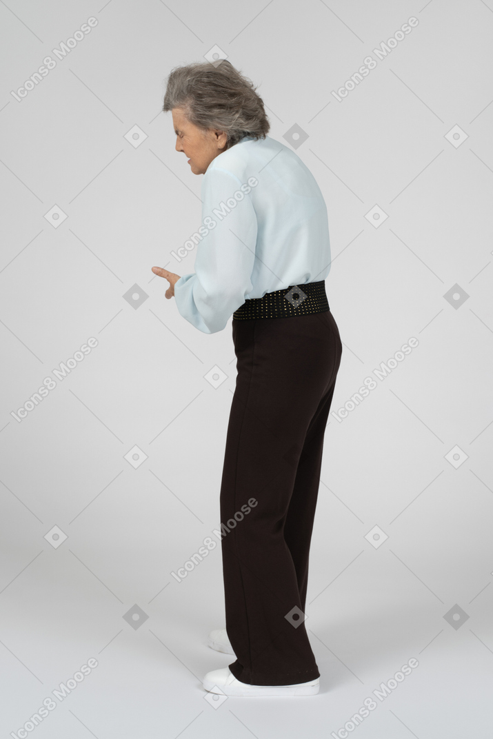 Vista lateral de una anciana haciendo una mueca y encorvada