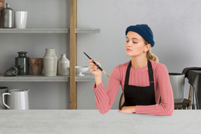 Painter in apron sitting in a pottery studio