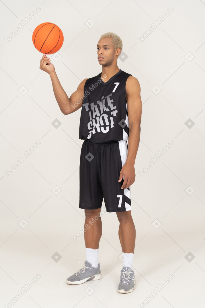 Three-quarter view of a young male basketball player holding a ball