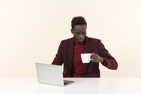 Elegante hombre negro sentado a la mesa en la oficina